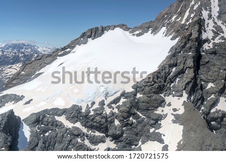 aerial, from a glider, with snow and blue ice on slope at Williams glacier, shot in bright spring light from west, Canterbury, South Island, New Zealand
