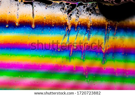 Psychedelic abstract planet from soap bubble, Light refraction on a soap bubble, Macro Close Up moving particles Rainbow colors on a black background. Model of Space or planets universe cosmic galaxy.