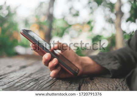 People hand using smartphone with blur cafe shop background. Business, financial, trade stock maket and social network concept.