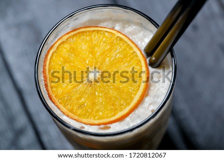 strawberry milkshake in a transparent glass on a black background top view close-up

