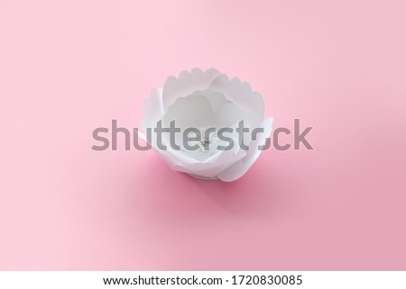 Handmade paper cutout white flower on pink background. Handmade art work. 