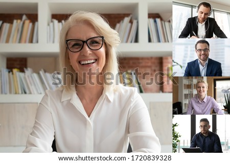 Smiling middle-aged businesswoman talk speak on video call with diverse multiracial colleagues, happy mature female employee engaged in webcam conference or online briefing with coworkers Royalty-Free Stock Photo #1720839328