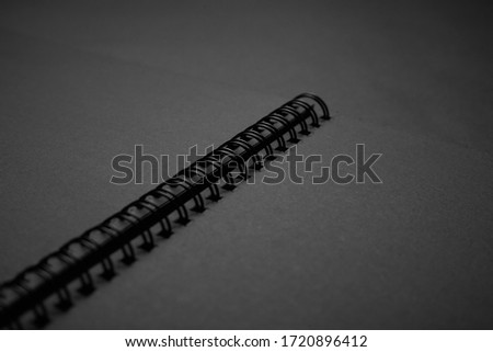 Blank black notebook on a black table, mockup photo. Blank black cover template with copy space for design. Black minimal design concept.