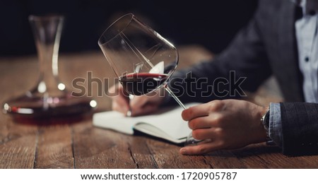 Sommeliers male hold glass red wine tasting degustation card. Royalty-Free Stock Photo #1720905787