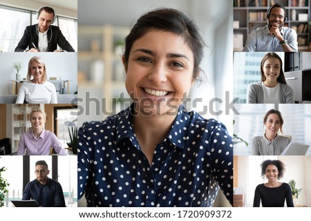 Smiling young indian female employee talk speak on video call with diverse colleagues, multiracial coworkers employees have webcam conference using modern app, engaged in web online briefing Royalty-Free Stock Photo #1720909372