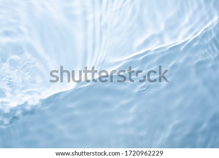 Soft focus lite purple blue gray cosmetic moisturizer floral water, micellar toner, or emulsion abstract background. Reflections of  scattered sun texture. Royalty-Free Stock Photo #1720962229