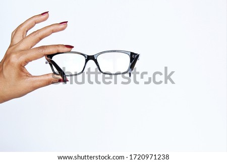Woman hand showing or holding black eyeglasses.photo isolate on white front view copy space 