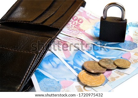Black leather wallet, Turkish lira banknotes and coins and padlock on white background. Finance safety concept
