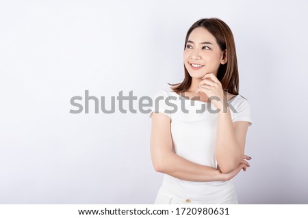 Asian pretty woman in white t-shirt and white pants pretending glad happy face with copy space on white background. Information telling, shopping promotion, announcement, selling support concept.
 Royalty-Free Stock Photo #1720980631