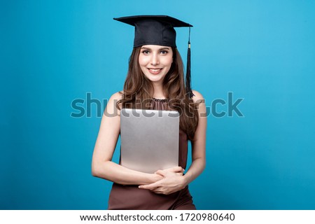 Mix race Asian Caucasian were Graduate hat and holding a laptop in seamless blue background. Education course, tutor concept, online education concept.
