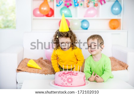 Children Blowing Out Candles on a Birthday Cake.A little blurred motion and shallow doff. 