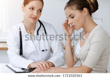 Doctor and patient sitting and discussing health examination results in sunny clinic