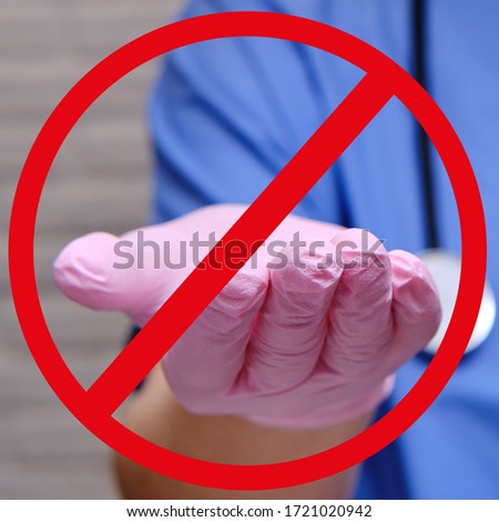 Crossed out hand in a medical protective glove, closeup. Outstretched hand of a doctor in a red circle banned