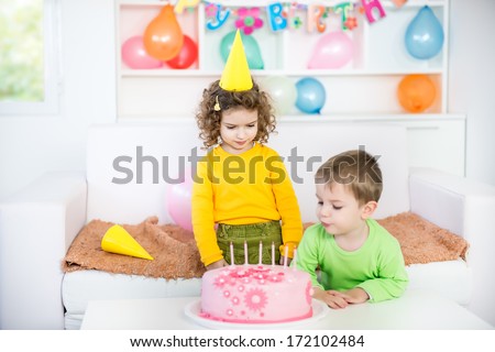 Children Blowing Out Candles on a Birthday Cake. Blurred motion and shallow doff.