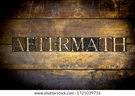 Photo of real authentic typeset letters Aftermath text on vintage textured grunge copper and gold background