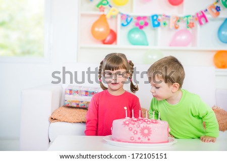 Children Blowing Out Candles on a Birthday Cake .Blurred motion and shallow doff. 