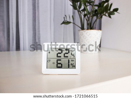 Thermometer hygrometer measuring the optimum temperature and humidity in a house, apartment or office, a photo for articles about the house’s microclimate, health, disease relief and virus treatment Royalty-Free Stock Photo #1721066515