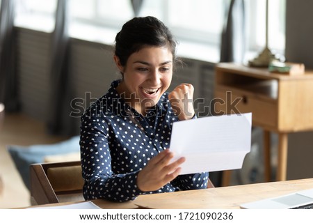 Excited young indian woman holding paper document, making yes gesture, celebrating job promotion, last mortgage payment bank notification. Happy hindu student received university admission letter. Royalty-Free Stock Photo #1721090236