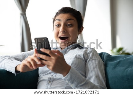 Head shot surprised young indian girl looking at phone screen. Amazed overjoyed millennial hindu woman reading sms with unexpectable unbelievable news with opened mouth, online lottery win concept. Royalty-Free Stock Photo #1721092171