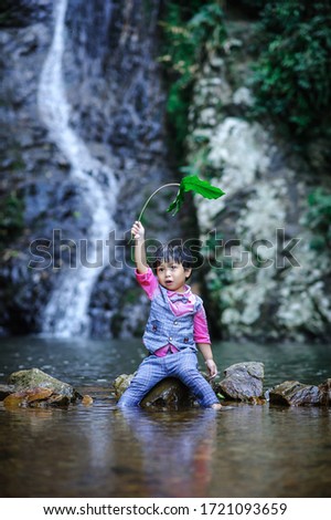 Happy children at the waterfall, cute​ child​ relax​ing​ at​ the​ waterfall, 