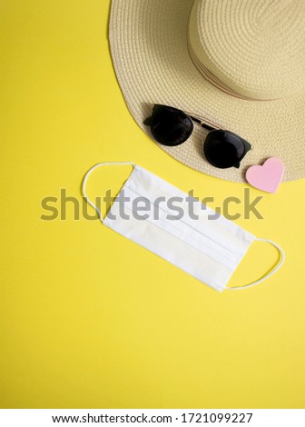 Mask flat lay composition with summer holiday accessories on yellow background, top view. Happy Holidays
