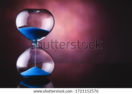 Blue sand hourglass on old background Royalty-Free Stock Photo #1721152576