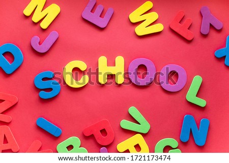 Word SCHOOL From Plastic Magnetic Letters On Red Background