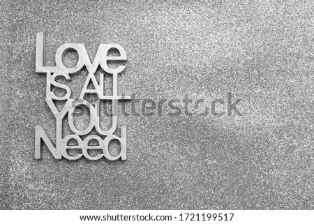 love is all you need -  wooden inscription isolated on gray silver background. decoration for weddings. empty copy space for inscription.                    