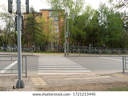 Pedestrian crossing through the street, regulated by a traffic light.