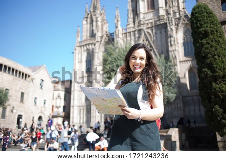 Portrait of cheerful caucasian female traveler excited with interesting vacations exploring european city, smiling beautiful woman 20s standing on square holding map for navigate and get to landmarks Royalty-Free Stock Photo #1721243236