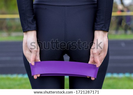 fitness girl holding three fitness gum stretchs for workout
