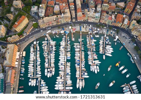 Aerial view of a harbor with vessels in a green water of Ligurian Sea, Santa Margherita Ligure, Italy. Yachts, motor and sailboats moored at the quay.