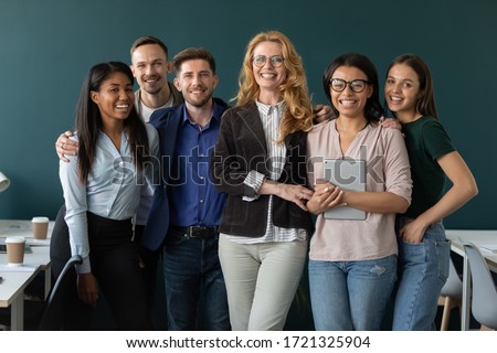 Portrait of standing in row smiling team embracing looking at camera. Happy diverse corporate staff, hugging specialists, company representatives, bank workers photo shoot, HR agency recruitments. Royalty-Free Stock Photo #1721325904