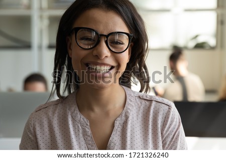 Close up headshot portrait picture of happy african american businesswoman with glasses. Smiling confident young diverse woman manager looking at camera on workplace background in office.