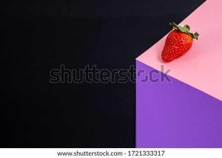 
Strawberry on smooth surface pink and purple with black background
