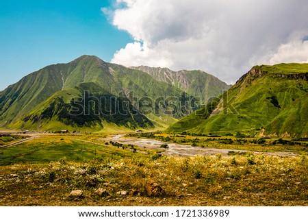 High and green mountains of Georgia. Sunny summer, blue sky. Horizontal landscape.