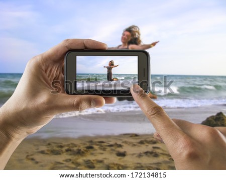 man taking a picture with your mobile phone a one woman jumping for joy on the beach