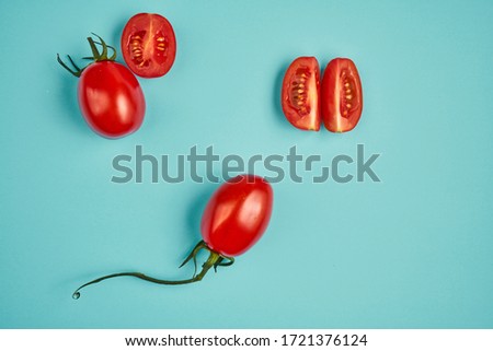 Red cherry tomatoes isolated on blue background