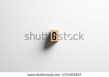 " G  " text made of wooden cube on  White background with clipping path.
