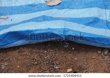 plastic fabric mat sheet place in white and blue. Laying on the ground
