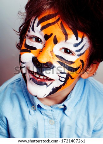 little cute boy with faceart on birthday party close up, little cute tiger, lifestyle people concept