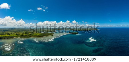 Panoramic picture in siargao, philippines, with Salvacion's beach located on the left side, the sea on the righ side, and the sky in the background 