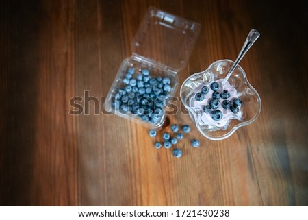 homemade natural fresh yogurt with blueberries in a glass bowl on a wooden table. type of superu