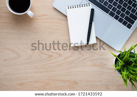Workplace in office with wood desk. Top view from above of laptop with notebook and coffee. Space for modern creative work of designer. Flat lay with blank copy space. Business and finance concept.