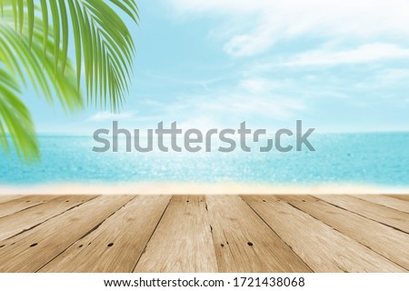 Blur Tropical summer beach with sun light abstract background and wood table for montage with copy space.  Beautiful summer vacation and business nature travel concept. 