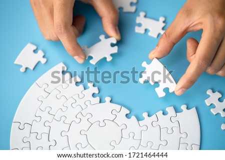Businessman hand connecting jigsaw puzzle, Business solutions,  target, success, goals and strategy concepts  Royalty-Free Stock Photo #1721464444