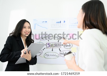 Two beautiful young asian business woman people have fun and talking or discuss about work in workplace