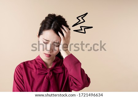 Young asian woman having head ache. Royalty-Free Stock Photo #1721496634