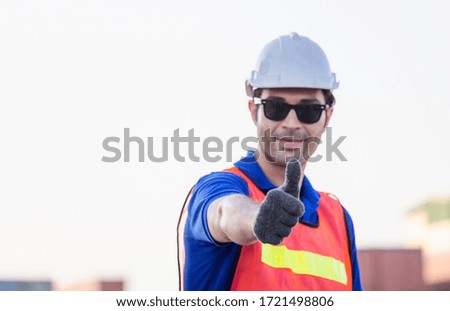 Cheerful factory worker man smiling with giving thumbs up as sign of Success