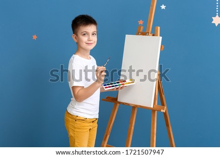 Cute little artist on color background